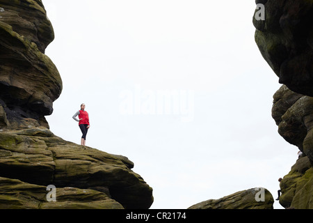 Donna in piedi sulle formazioni rocciose Foto Stock