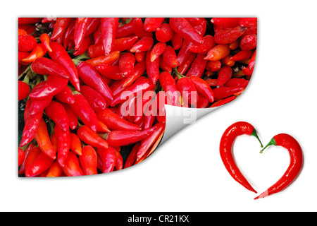 Un mucchio di peperoncino rosso immagine con due peperoni formando una forma di cuore. Amante calda simbolo. Foto Stock