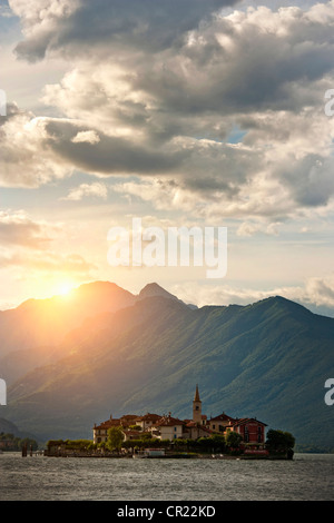 Sole che splende oltre il castello costruito sull'isola Foto Stock