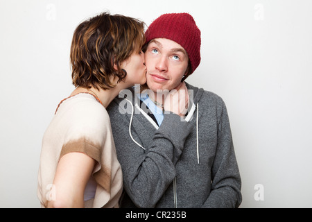 Studio shot della giovane donna kissing giovane uomo Foto Stock