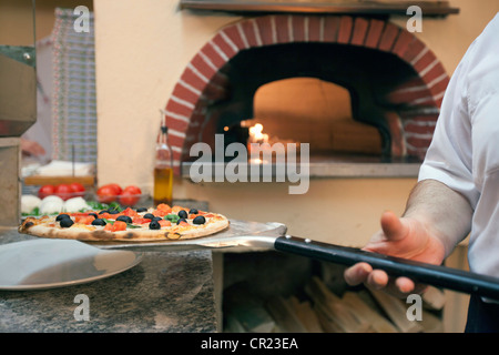 Lo Chef pizza di contenimento sulla spatola Foto Stock