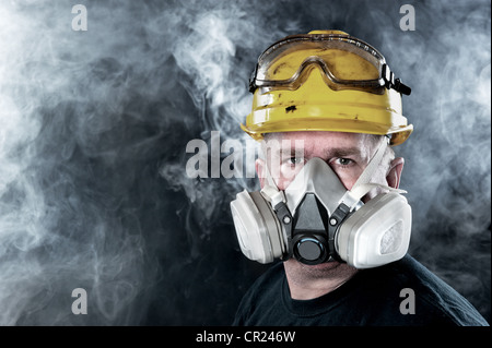 Un lavoratore di salvataggio indossa un respiratore in un fumo tossico, atmosfera. L'immagine mostra l'importanza della disponibilità di protezione e sicurezza. Foto Stock