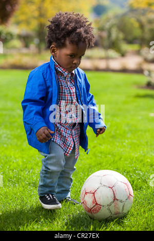 Outdoor ritratto di un simpatico baby nero che giocano a calcio Foto Stock