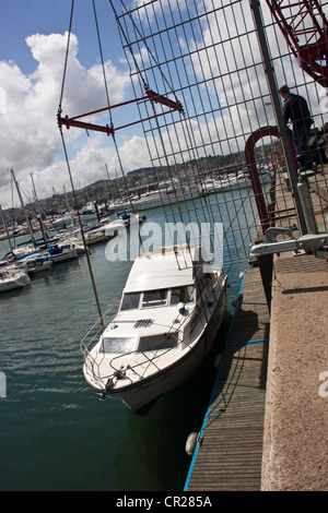 Yacht a motore (Alba Affair) per essere scaricato dal camion nella marina a Torquay, Devon, Regno Unito. Foto Stock