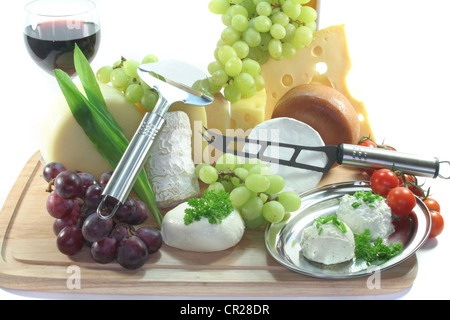 Formaggi con acini di uva fresca e pomodori Coltello per formaggio e formaggio Tagliatutto Foto Stock