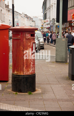 Vecchio rosso casella postale nella necessità di riverniciatura, Newton Abbot, Devon, Regno Unito. Foto Stock