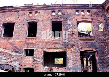 Il vecchio edificio abbandonato dopo il fuoco. scale di porta e finestra archi. retrò casa in mattoni rossi. Foto Stock