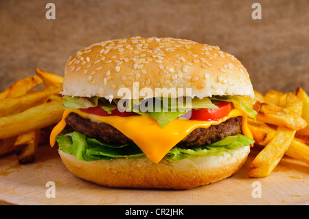 Cheeseburger con patatine fritte su un piatto di legno Foto Stock