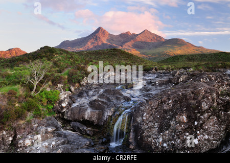 Cascata sul Allt Dearg Mor, con il soleggiato picchi del Black Cuillin Hills in background Foto Stock