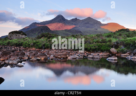 Rosa alba la luce del sole sulle punte di Black Cuillin Hills, riflesso nel fiume Sligachan sull'Isola di Skye Foto Stock