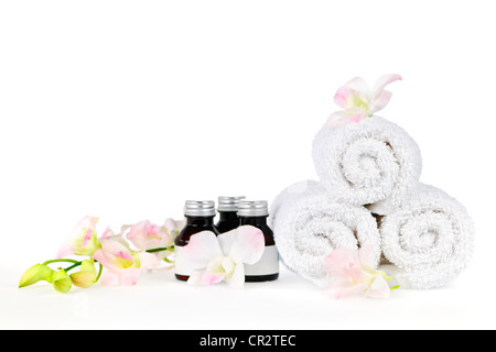 White arrotolato spa asciugamani e prodotti per la cura del corpo con fiori di orchidea Foto Stock