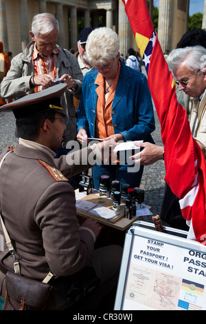 Germania Berlino quartiere Mitte Porta di Brandeburgo attore vestito come soldato timbro cartolina con tutti i precedenti visa di epoca comunista Foto Stock