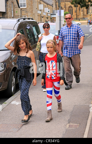 Famiglia a camminare con una figlia vestito in abiti patriottico durante la regina del weekend del Giubileo Foto Stock