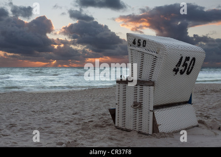 Con tetti di vimini sedia spiaggia sulla spiaggia appena dopo il tramonto con nuvole drammatico, Hoernum, Sylt, Frisia settentrionale, Schleswig-Holstein Foto Stock