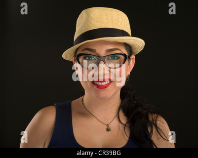 Giovane messicano donna americana con gli occhiali un stile di panama cappello di paglia con nastro nero e rossetto rosso Foto Stock