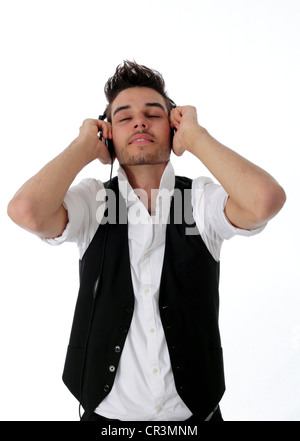 Giovane uomo che indossa gli auricolari sorridente con soddisfazione con i suoi occhi chiusi come egli è rapita dalla sua musica Foto Stock