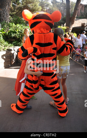 La Tigger carattere da molte avventure di Winnie the Pooh attrazione abbracci i bambini al parco di Disneyland, Anaheim, California Foto Stock