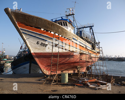 In legno barca di pesca presso un cantiere navale nel porto di Essaouira, Marocco, Africa Settentrionale, Africa Foto Stock