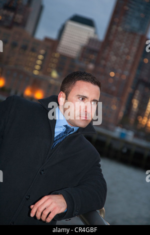 Ritratto di uomo caucasico in business suit con casacca sulle strade di New York City America al tramonto con la città in background Foto Stock