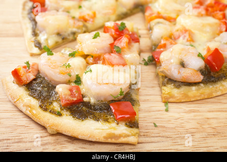 In base croccante pizza guarnita con gamberi e pepe rosso, mozzarella e pesto di basilico. Foto Stock