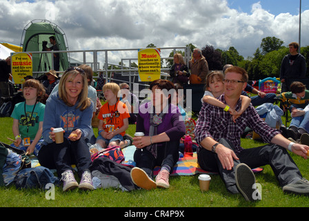 Famiglia di frequentatori del festival godendo Alresford Music Festival, Alresford, Hampshire, Regno Unito. Il 9 giugno 2012. Foto Stock