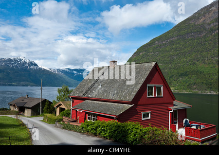 Rosso di tipica casa in legno su Hardanger fiordo, Norvegia, Scandinavia, Nord Europa, PublicGround Foto Stock