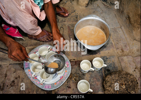 La donna che serve la tradizionale tè nero con latte, Chai, Lahore Punjab, Pakistan, Asia Foto Stock