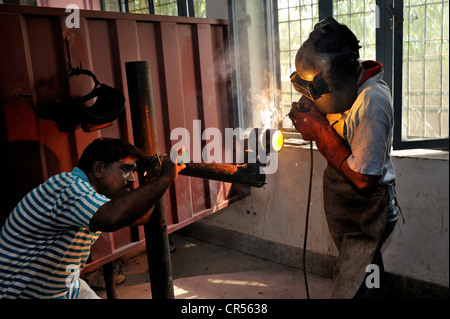 La formazione professionale come un lavoratore metalmeccanico, insegnante, sinistra, controllo della tecnica di saldatura di una formazione studente, Youhanabad, Lahore Foto Stock