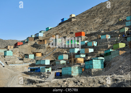 Dipinto luminosamente case di legno costruite su pendii di sabbia nel clima secco del deserto, baraccopoli di Amauta, Lima, Perù, Sud America Foto Stock