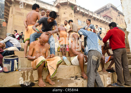 Testina di rasatura e la barba è parte del rituale per l'addio all'anima di una persona deceduta a ghats di , India, Asia Foto Stock