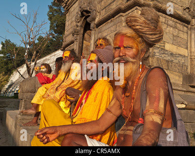 Un gruppo di Sadhus, Santo uomini provenienti da India, appoggiata al tempio di Pashupatinath a Kathmandu, Nepal, Sud Asia Foto Stock