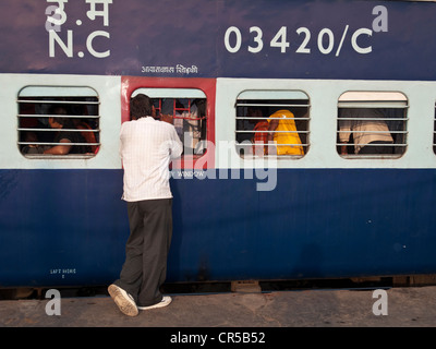 Uomo che parla di treno passeggero prima della partenza del treno dalla Stazione Ferroviaria di New Delhi, Nuova Delhi, India, Asia Foto Stock