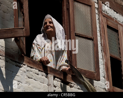 Donna locale guardando fuori della sua finestra, Srinagar, Jammu e Kashmir, India, Asia Foto Stock