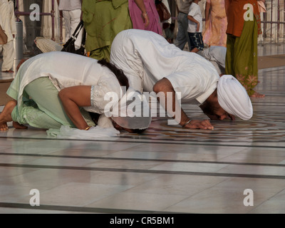 La religione sikh devoti di pregare all'entrata della Golden tempio complesso, Amritsar Punjab, India, Asia Foto Stock