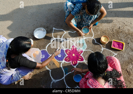 Donne che fanno Rangoli, Sabbia decorativa progetta per le strade di Madurai durante un festival indù, inteso come sacro accogliente area Foto Stock