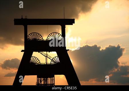 Torre di avvolgimento di un ex miniera di carbone, tramonto, dark sky, nuvole. Simbolo per la fine delle miniere di carbone della Ruhr, Germania. Foto Stock