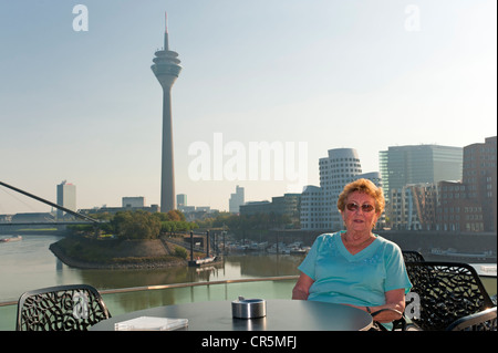 Titolare di pensione o di rendita seduto su una terrazza in Media Harbour Duesseldorf, nella Renania settentrionale-Vestfalia, Germania, Europa Foto Stock