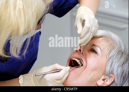 Assistente dentale controllo a denti del paziente Foto Stock