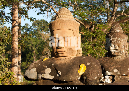 Copia della testa di un Dio con gli occhi a mandorla e un copricapo conico all'ingresso della Porta Sud di Angkor Thom, Foto Stock