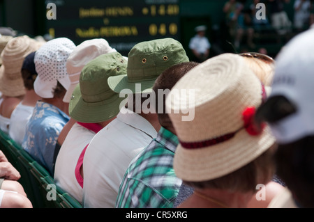 Una fila di persone che indossano cappelli sul Centre Court, Wimbledon. Foto Stock