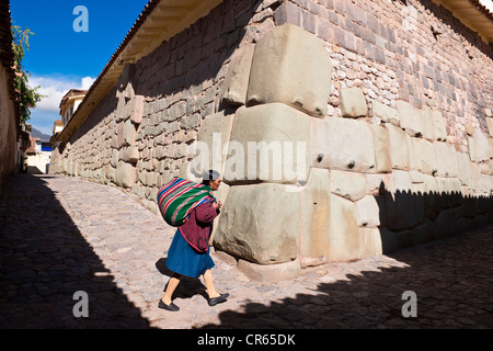 Il Perù, Provincia di Cuzco, Cuzco, patrimonio mondiale dell UNESCO, Calle Hatun Rumiyoc, Indiani Quechua davanti a rimangono di un muro Inca Foto Stock