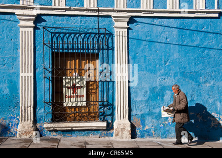 Il Perù, Provincia di Arequipa, Arequipa, centro storico Patrimonio Mondiale dell'UNESCO, l'uomo la lettura di un quotidiano nella parte anteriore di un colorato Foto Stock