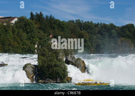 Rock in mezzo al frastuono acque delle cascate del Reno di Schaffhausen, escursione turistica barca sulla parte anteriore, Svizzera, Europa Foto Stock