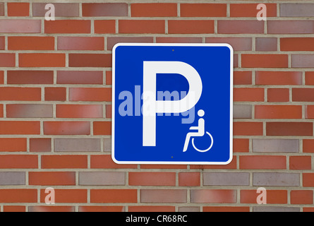 Segno con il pittogramma sul muro di mattoni: disabili Parcheggio Foto Stock