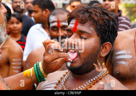 Pellegrino con linguetta spirituale piercing, festival indù Thaipusam, Grotte Batu, grotte di pietra calcarea e templi, Kuala Lumpur, Malesia Foto Stock