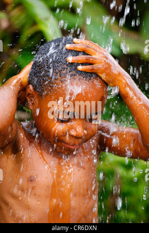 Il ragazzo, 6 anni sotto una doccia di Bamenda, Camerun, Africa Foto Stock