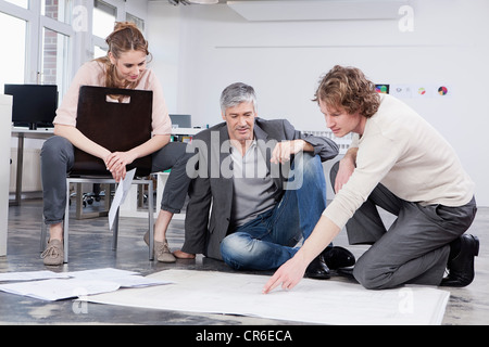 In Germania, in Baviera, Monaco di Baviera, uomo piano di spiegare ai colleghi in ufficio Foto Stock