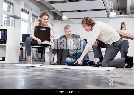 In Germania, in Baviera, Monaco di Baviera, uomo piano di spiegare ai colleghi in ufficio Foto Stock