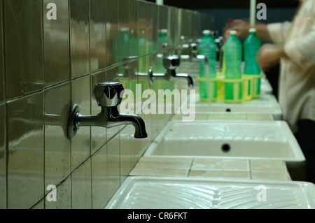 Uomo di ottenere acqua in bottiglie di plastica, wc pubblico, campeggio, Lido di Ostia, Roma, Regione Lazio, Italia, Europa Foto Stock