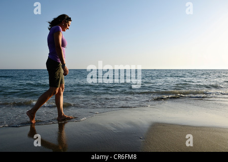 Donna di camminare sulla spiaggia, Lido di Ostia, Roma, Regione Lazio, Italia, Europa Foto Stock